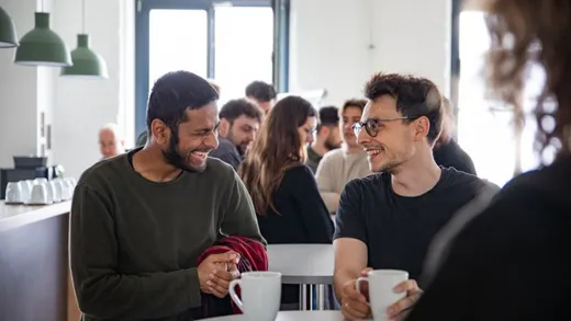 BII-Kolleginnen und -Kollegen im Gespräch bei Kaffee während der Townhall